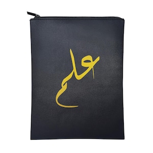 Op de afbeelding: Zwarte, rechthoekige etui met gouden Arabische kalligrafie. De etui heeft een zwarte ritssluiting. De gouden kalligrafie staat in het midden op de voorkant. Gemaakt van een getextureerd materiaal.