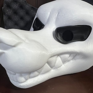 May include: White foam blank fursuit head with a toothy grin and black eye holes. The head is unpainted and ready for customization.