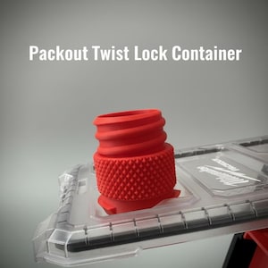 May include: A red Packout Twist Lock Container component with a textured grip and threaded top. The container is partially inserted into a clear plastic base with the Milwaukee logo visible.