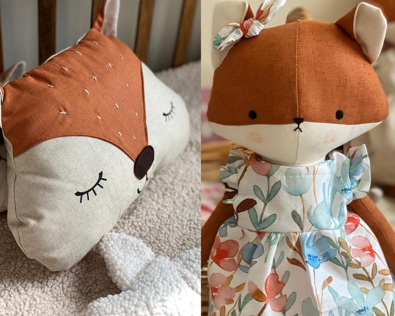 May include: Two plush fox toys. One is a flat pillow with a brown face and closed eyes. The other is a standing fox wearing a white dress with a floral pattern.