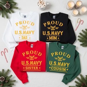 May include: Four sweatshirts in white, black, red, and green, each with "PROUD U.S. NAVY" printed in gold. The white sweatshirt says "DAD", the black says "MOM", the red says "SISTER", and the green says "COUSIN".