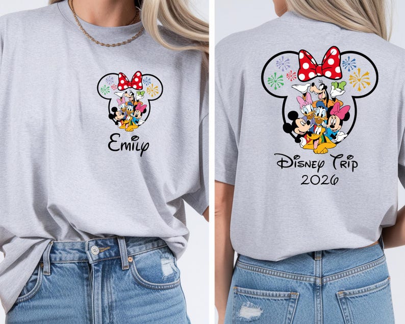 a woman wearing a gray t-shirt with a Disney-themed design featuring Minnie Mouse and other Disney characters. The t-shirt has a personalized name printed on it, and the back of the shirt displays the text "Disney Trip 2026".