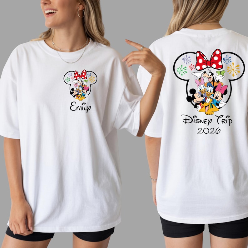A woman wearing a white t-shirt with a Disney character design and text on the back.