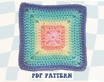 May include: A crochet square with a rainbow gradient pattern. The square is made with different shades of blue, green, yellow, pink, and purple yarn. The text "PDF PATTERN" is printed below the square.