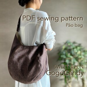 May include: A brown and tan Pão bag, a PDF sewing pattern, is shown over the shoulder of a person wearing a white shirt. The bag has a rounded shape and is made of a textured fabric. The text "SWEET & FUN GogoCandy" is in the lower right corner.