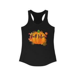 以下が含まれることがあります： 鮮やかなオレンジ色のカボチャのグラフィックと「Fall Vibes」の文字が秋の葉で囲まれた黒いレーサーバックタンクトップ。このデザインは、秋にぴったりの季節感あふれる秋のテーマを連想させます。