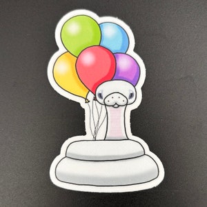 Op de afbeelding: Een witte slang met een roze lichaam en een glimlachend gezicht houdt vier ballonnen vast. De ballonnen zijn geel, groen, rood en paars.