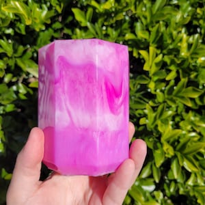 May include: A pink and white hexagonal resin planter with a swirled design.
