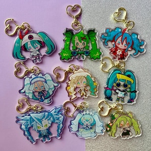 Könnte beinhalten: Eine Sammlung von neun Acryl-Schlüsselanhängern mit Anime-Charakteren mit leuchtenden Haaren und Outfits. Jeder Schlüsselanhänger hat einen goldfarbenen herzförmigen Verschluss. Die Charaktere haben verschiedene Posen und Ausdrücke mit unterschiedlichen Farbschemata.