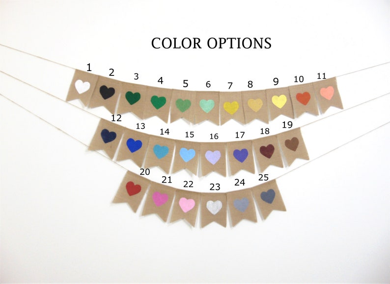 Puede incluir: Una pancarta de arpillera con 25 formas de coraz&oacute;n de diferentes colores. La pancarta est&aacute; enhebrada con una cuerda blanca. Los colores incluyen blanco, negro, verde, azul verdoso, amarillo, naranja, rojo, rosa, azul, morado, marr&oacute;n y gris.