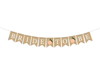 Può includere: Uno striscione di juta con le parole "Bride to Be" in lettere bianche. Ogni lettera è su una bandiera separata con un'illustrazione di pesca al centro.