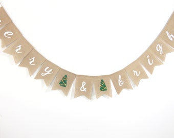 May include: A burlap banner with the words "Merry & Bright" in white lettering. The banner has small green Christmas trees with yellow lights on each side of the ampersand.