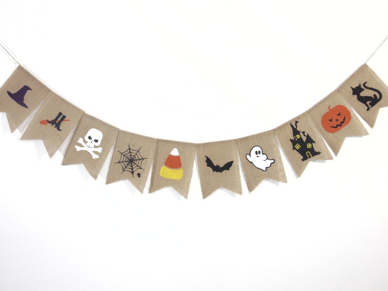 Puede incluir: Una guirnalda de arpillera con tem&aacute;tica de Halloween con varios iconos festivos. La guirnalda presenta un sombrero de bruja, botas, una calavera, una telara&ntilde;a, caramelos de ma&iacute;z, un murci&eacute;lago, un fantasma, una casa embrujada, una calabaza y un gato negro.