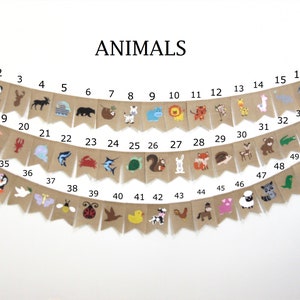 May include: A burlap banner with the word "ANIMALS" printed in black at the top. The banner is decorated with 49 different animal illustrations, each numbered from 1 to 49. The animals include a panda, a deer, a moose, a bear, a sloth, a zebra, a hippopotamus, a lion, a tiger, a monkey, a giraffe, a llama, an elephant, a seahorse, a lobster, a unicorn, a shark, a crab, a turtle, a squirrel, a rabbit, a fox, a hedgehog, a fawn, a bear, an alligator, a spider, a penguin, a dove, a butterfly, a bee, a ladybug, a bird, a duck, a cow, a rooster, a horse, a pig, a sheep, a raccoon, and a dinosaur.