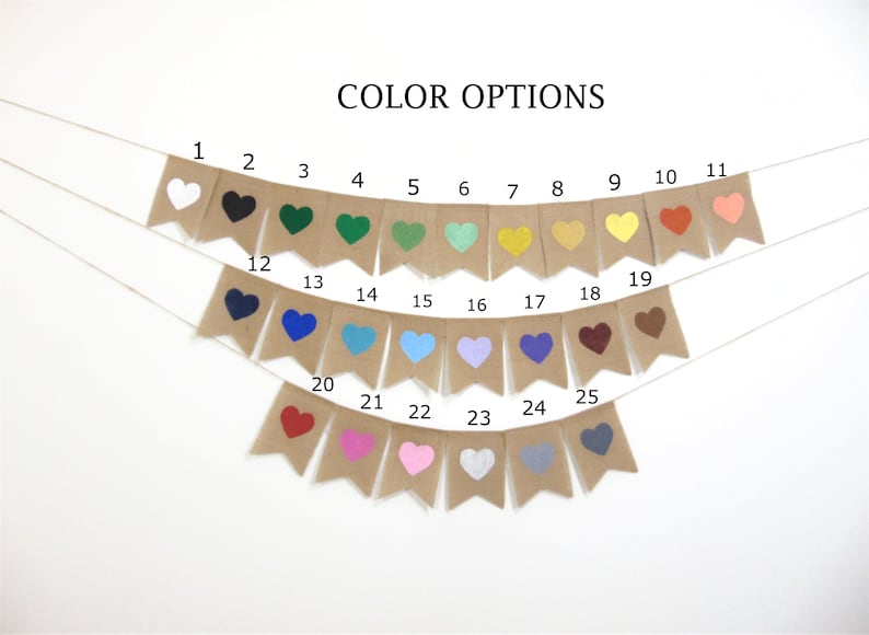 May include: A burlap banner with 25 different coloured heart shapes. The banner is strung with white twine. The colours include white, black, green, teal, yellow, orange, red, pink, blue, purple, brown, and grey.