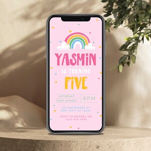 May include: A pink smartphone screen displaying a birthday invitation for Yasmin's fifth birthday. The invitation features a rainbow with stars and a cloud. The text reads "Yasmin is turning Five" with the date and time of the party below.