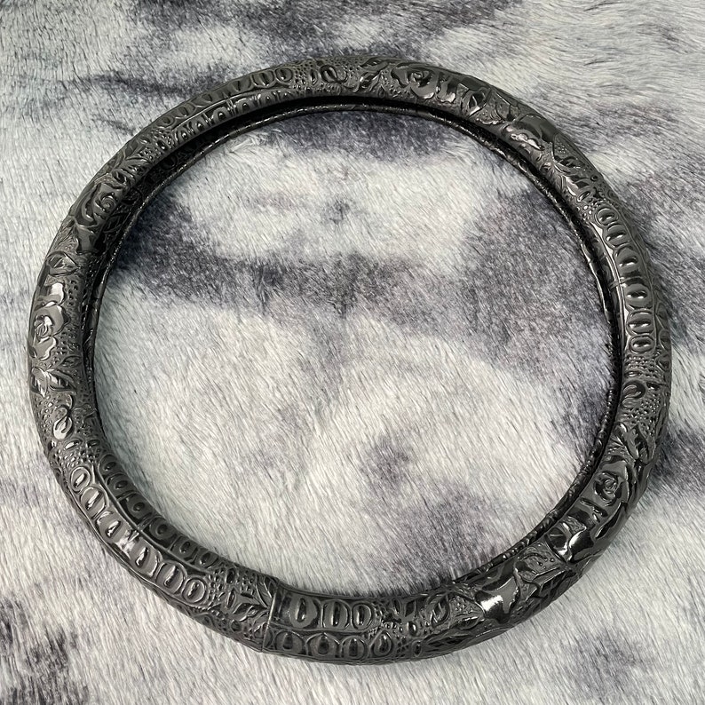 Peut inclure: Un couvre-volant de voiture circulaire noir avec un motif floral d&eacute;taill&eacute;. Le couvre-volant est fait d'un mat&eacute;riau durable et a une finition lisse et brillante.