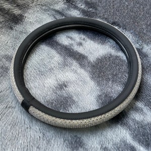 May include: Black leather steering wheel cover with a silver rhinestone trim.