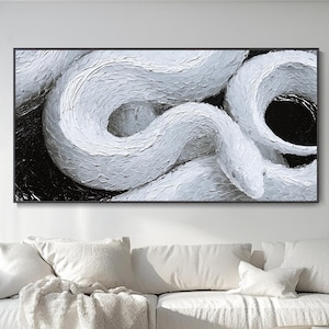 Op de afbeelding: Een rechthoekig wandkunstwerk met een getextureerd schilderij in impasto-stijl van een opgerolde witte slang tegen een diepzwarte achtergrond. De dikke, gelaagde witte verf creëert een driedimensionaal effect op de schubben van de slang.