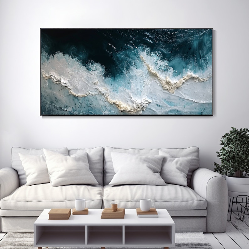 May include: Abstract painting of swirling blue and white waves with hints of gold. The painting is framed in a black frame and is hanging on a white wall.