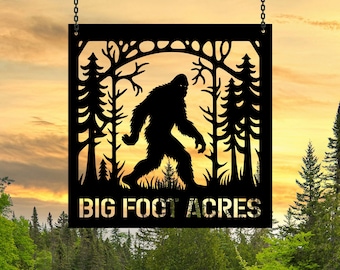 May include: Black metal sign with a silhouette of Bigfoot walking through a forest. The sign reads "Big Foot Acres".