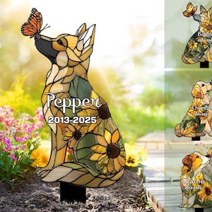 Könnte beinhalten: Ein Gartenstecker im Buntglas-Stil zeigt einen sitzenden Hund mit einem Schmetterling auf der Nase. Das Design enthält gelbe Sonnenblumen und grüne Blätter. Der Text Pepper und 2013-2025 ist aufgedruckt. Weitere Varianten zeigen die Namen Bailey, Charlie und Charlie mit Daten.