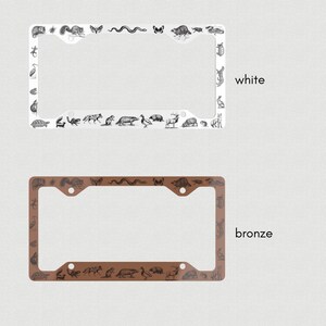 May include: Two license plate frames, one white and one bronze, with a black and white illustration of various animals around the border. The text "white" and "bronze" are printed below each frame.