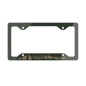 May include: Dark green license plate frame with a mountain and forest silhouette design. The frame features a bear, trees, mountains, and a deer. The frame has a starry night sky pattern.