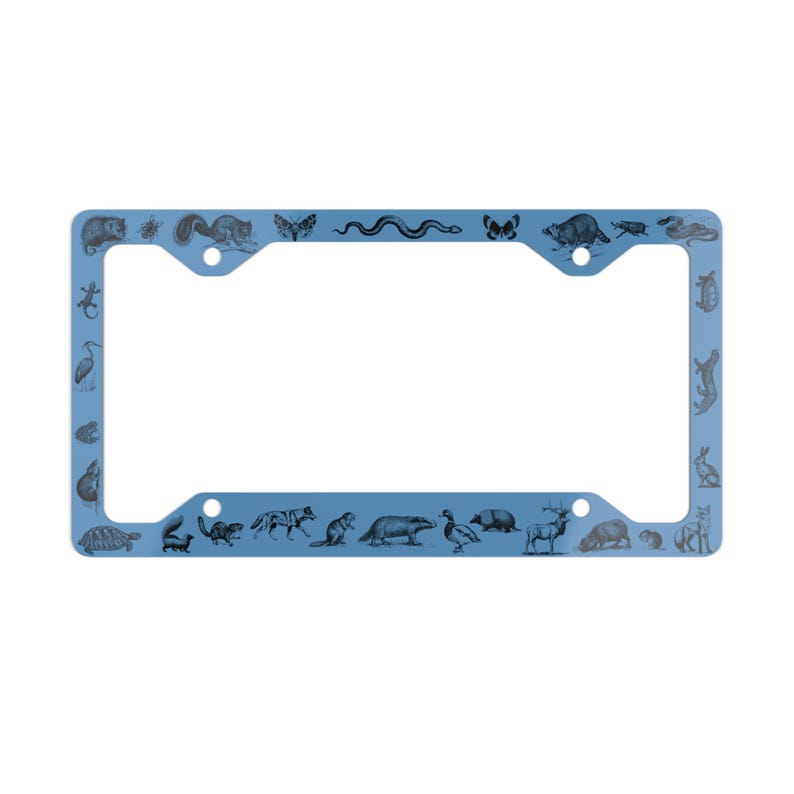 May include: A light blue license plate frame with a black and white design of various animals, including a snake, a turtle, a deer, a bird, and a butterfly.
