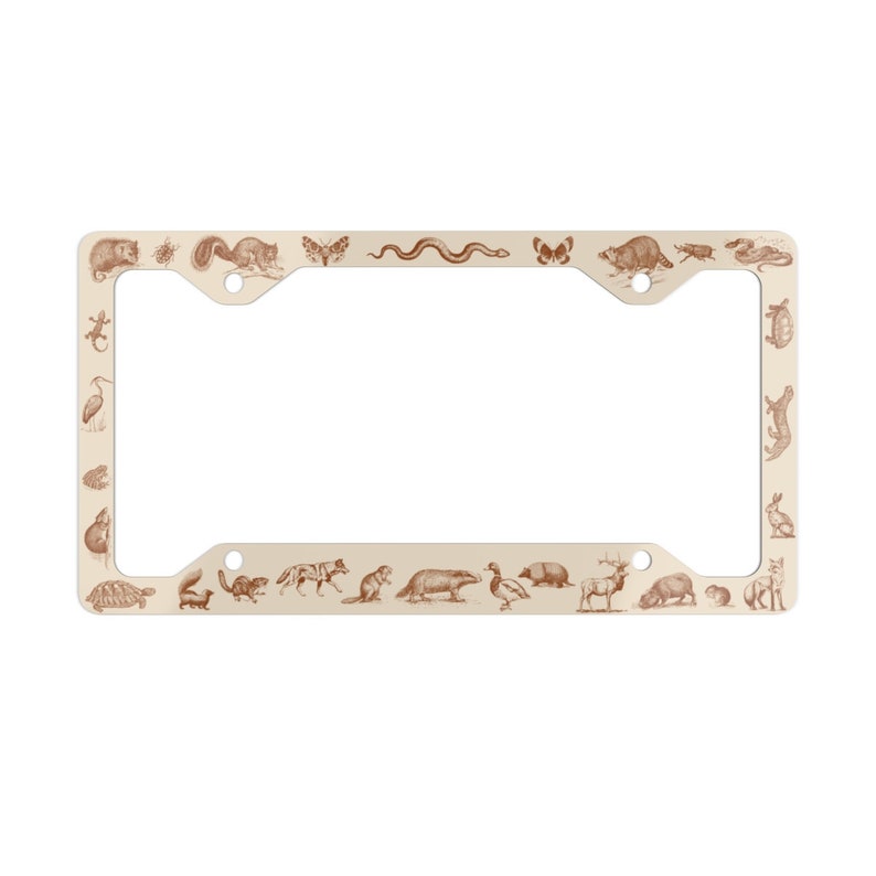 May include: A cream-colored metal license plate frame with a brown outline. The frame is decorated with a variety of animals, including a snake, a butterfly, a squirrel, a turtle, a deer, a duck, and a rabbit.