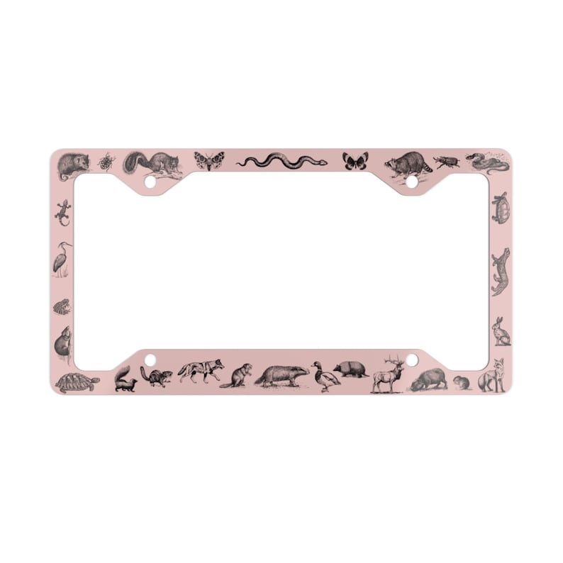 May include: A pink metal license plate frame with a black and white illustration of various animals around the border. The animals include a turtle, squirrel, snake, butterfly, deer, and more.