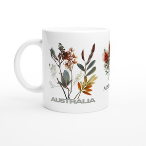 May include: White ceramic mug with a floral design featuring dried flowers in shades of orange, yellow, green, and brown. The word "AUSTRALIA" is printed in gray on the mug.