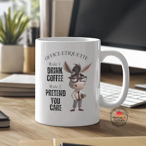 以下が含まれることがあります： 白地に黒と白のイラストが描かれたセラミック製のコーヒーカップ。イラストは眼鏡とネクタイをつけたロバ。カップには「OFFICE ETIQUETTE」と「Rule 1 DRINK COFFEE Rule 2 PRETEND YOU CARE」の文字が印刷されている。