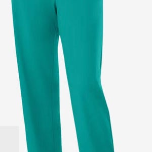 Puede incluir: Pantalones de color turquesa con diseño de pierna recta. Los pantalones tienen cintura elástica y bolsillos. La modelo lleva bailarinas marrones. Los pantalones están hechos de una tela suave y fluida.