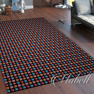 Può includere: Un tappeto nero con un motivo ripetuto di fantasmi Pac-Man colorati. I fantasmi sono in tonalità di rosa, blu, arancione e rosso.