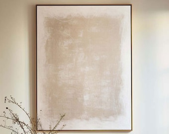 Op de afbeelding: Een groot rechthoekig wandkunstwerk met een beige en gebroken wit gestructureerd abstract ontwerp in een dunne lijst, geplaatst boven een beige gestoffeerde bank met een houten onderstel, een vaas met droge takken en een donkerbruine salontafel.