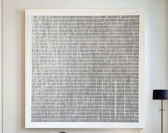 May include: A large square wall art piece featuring a black and white grid pattern of vertical lines. The artwork is displayed above a long wooden bench with a white cushion, two small dark bowls, a floor lamp, and a black side table.