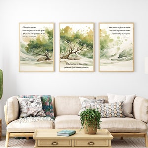 May include: Three watercolor paintings with inspirational quotes about trees and nature. The paintings are framed in wood and hung on a white wall above a beige sofa.