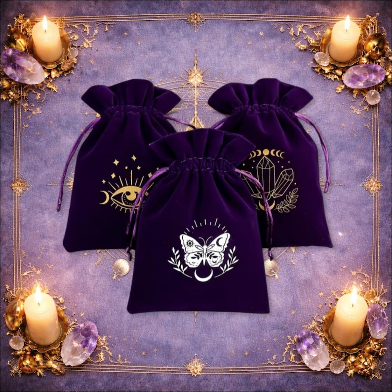 May include: Three deep purple velvet drawstring pouches featuring gold-coloured screen-printed designs. One bag displays an eye with celestial motifs, another shows a cluster of crystals with moon phases, and the third features a butterfly with moon symbols.