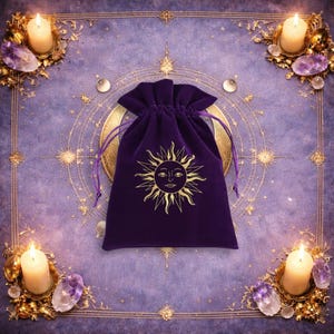 May include: A deep purple velvet drawstring pouch featuring a gold-coloured sun graphic with a face at the centre. The pouch has a gathered top closure with matching purple fabric cords on each side, designed for holding small items securely.