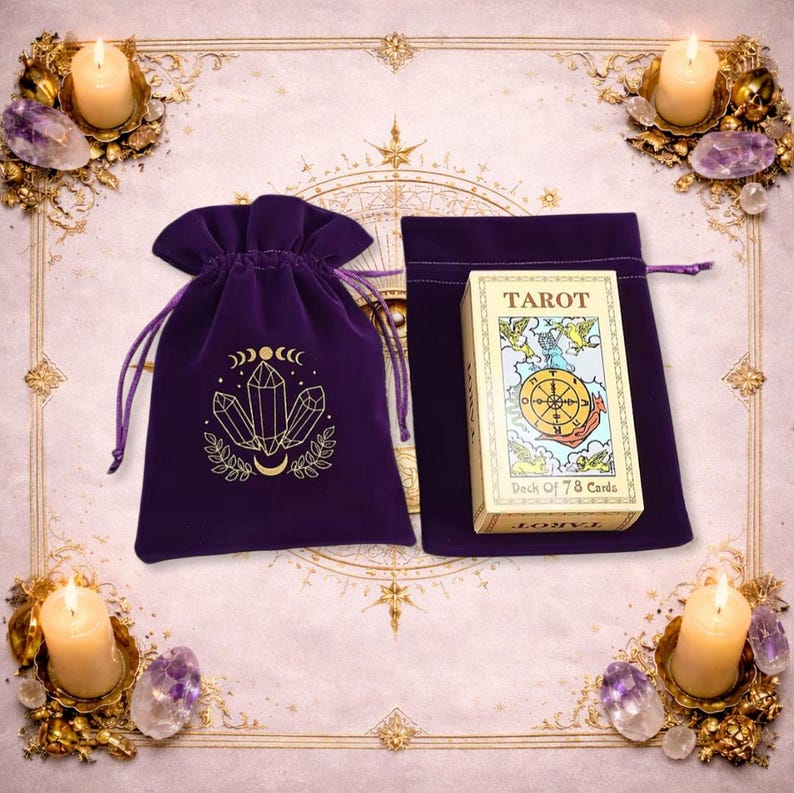 May include: A purple velvet drawstring pouch featuring a gold-printed crystal and moon design, accompanied by a rectangular box of 78 tarot cards. The box displays the word TAROT and an illustration of a wheel surrounded by winged figures.
