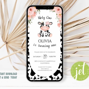 May include: A digital invitation on a smartphone screen. The invitation features a cartoon cow with floral accents and the text "Holy Cow." It announces Olivia's first birthday, with event details. The phone has a black and white cow print border.