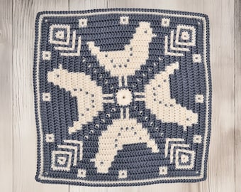 May include: A square crocheted throw pillow with a geometric design featuring four stylized birds in white on a blue background.