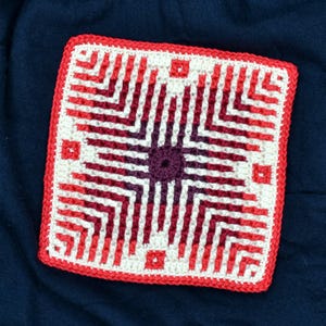 May include: A crocheted square with a red, white, and burgundy color gradient. The square is made with a repeating pattern of stripes and zigzags.