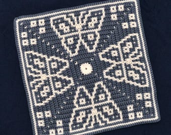May include: A square crocheted blanket with a geometric pattern in white and blue. The pattern is symmetrical and features a central circle.