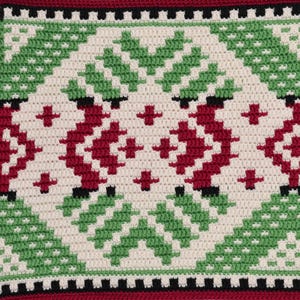 Puede incluir: Primer plano de una tela de crochet con un patrón repetido de cuadrados verdes, rojos y blancos. La tela tiene una superficie texturizada y un diseño geométrico.