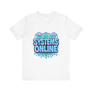 May include: White t-shirt featuring the text "SYSTEMS ONLINE" in a bubble font, with a circuit board design and blue and pink accents. The design includes cloud shapes and star details.