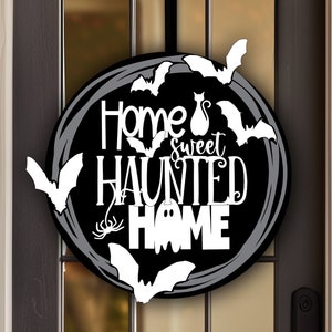 May include: Black and white Halloween door hanger with the text "Home Sweet Haunted Home" surrounded by bats and a ghost.