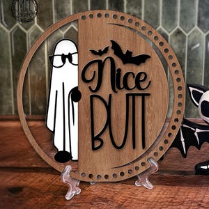 May include: A Halloween-themed wooden sign with the phrase "Nice Butt" and a cartoon ghost wearing glasses. A black and white bat figurine is next to the sign. The words "Digital Download" are at the bottom.