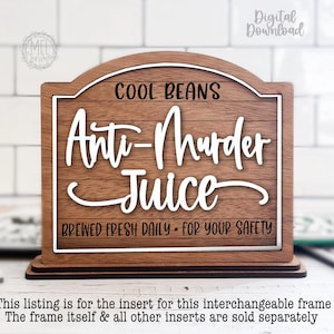May include: Wooden sign with the text "COOL BEANS Anti-Murder Juice BREWED FRESH DAILY FOR YOUR SAFETY". The sign has a brown wood grain background with white lettering and a white border. The sign is on a wooden base.